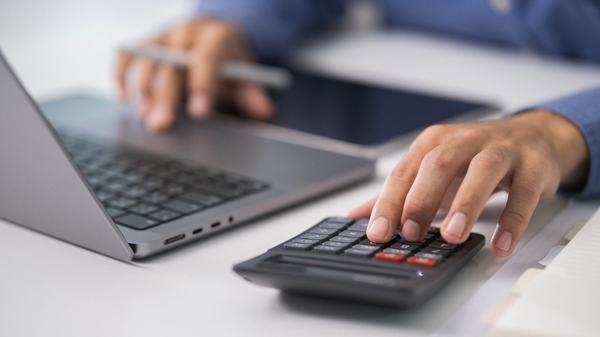 Photo d'un homme sur son ordinateur et tapant sur une calculatrice
